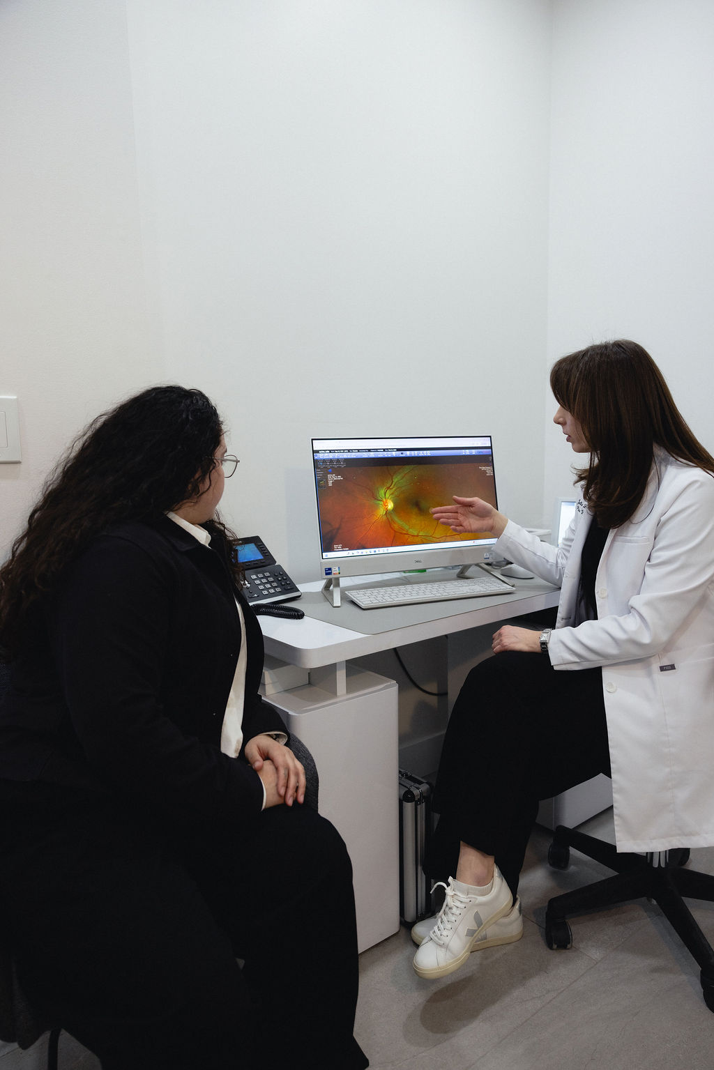 PVC doctor showing a patient their retinal map on a digital tablet.
